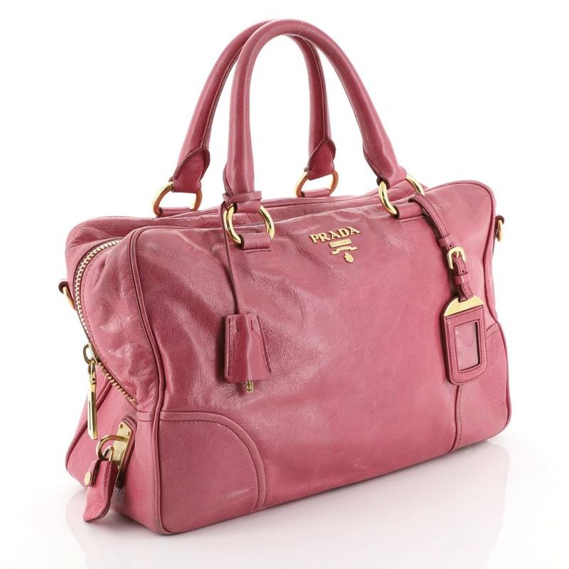 Prada Convertible Bauletto Bag Vitello Shine Medium 
This Prada Convertible Bauletto Bag Vitello Shine Medium, crafted from pink vitello shine leather, features dual rolled handles, raised Prada Milano logo, protective base studs and gold-tone