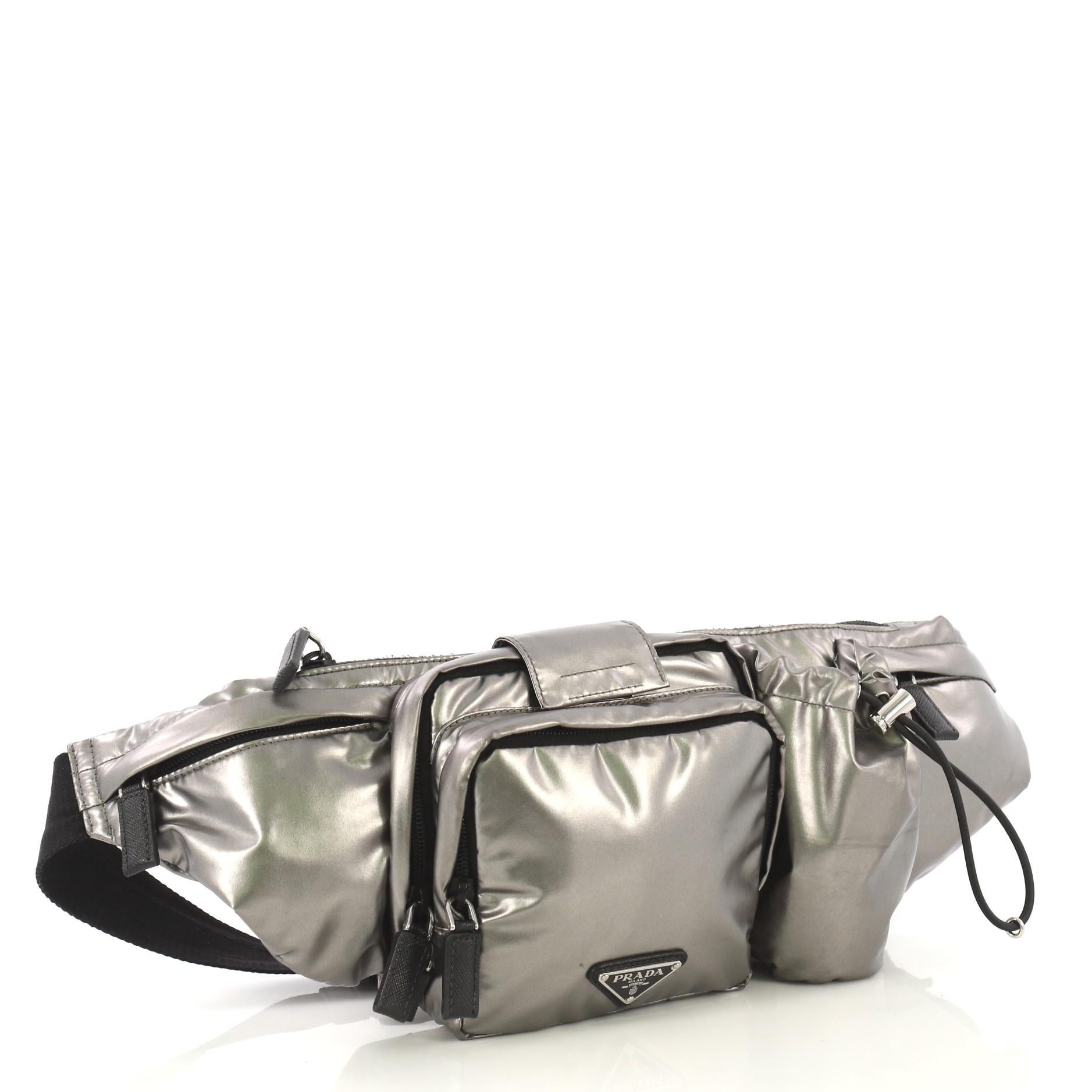 This Prada Convertible Multipocket Belt Bag Tessuto Medium, crafted in silver metallic tessuto, features an adjustable belt strap, multiple exterior pockets, and and silver-tone hardware. Its top zip closure opens to a black nylon interior.