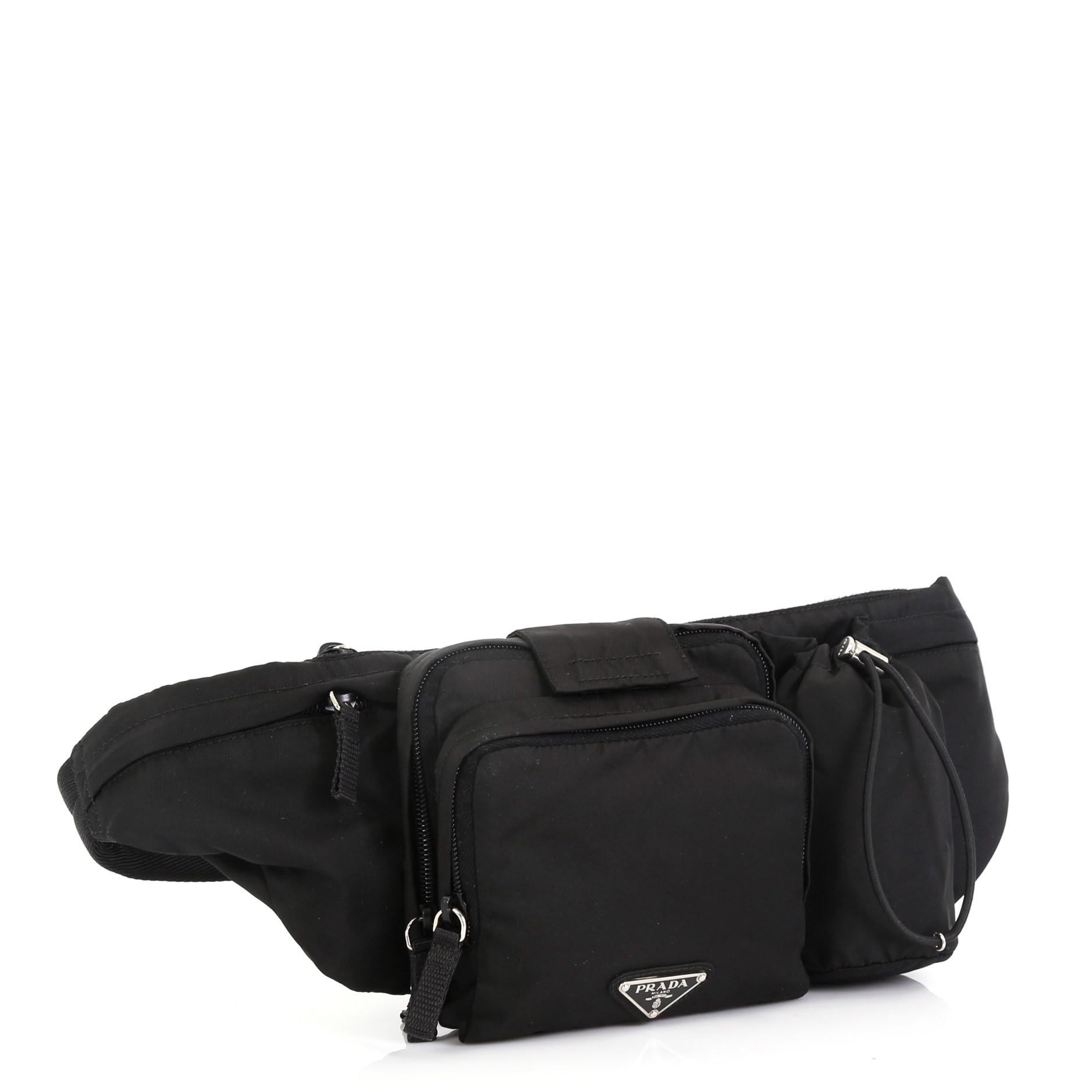 This Prada Convertible Multipocket Belt Bag Tessuto Medium, crafted in black tessuto nylon, features an adjustable belt strap, and silver-tone hardware. It opens to a black fabric interior. 

Estimated Retail Price: $807
Condition: Excellent. Faint