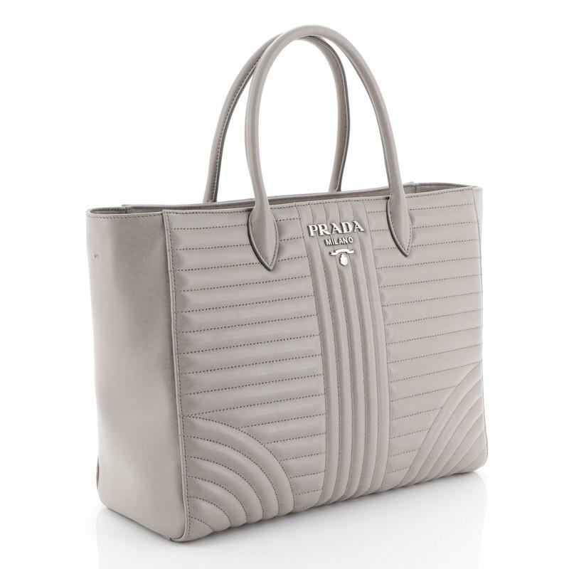 This Prada Convertible Open Tote Diagramme Quilted Leather Medium, crafted from neutral diagramme quilted leather, dual top handles and silver-tone hardware. It opens to a gray fabric interior with zip and slip pockets. 

Estimated Retail Price: