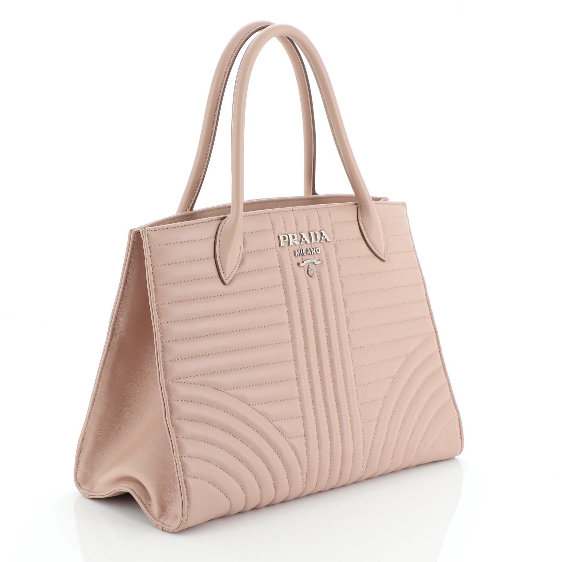 This Prada Convertible Open Tote Diagramme Quilted Leather Medium, crafted from neutral diagramme quilted leather, dual top handles and silver-tone hardware. It opens to a neutral fabric interior with zip and slip pockets.

Estimated Retail Price: