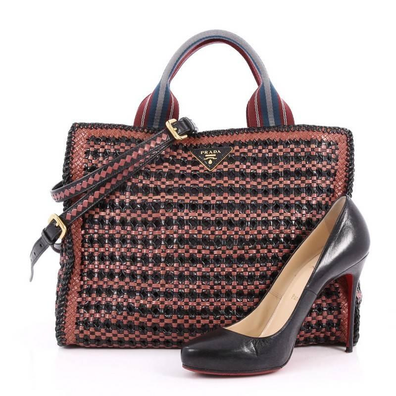 This authentic Prada Convertible Open Tote Madras Woven Leather Medium is a stylish and functional bag perfect for your daily excursions. Crafted in mauve and black mardas woven leather, this tote features dual woven handles, Prada triangle logo,