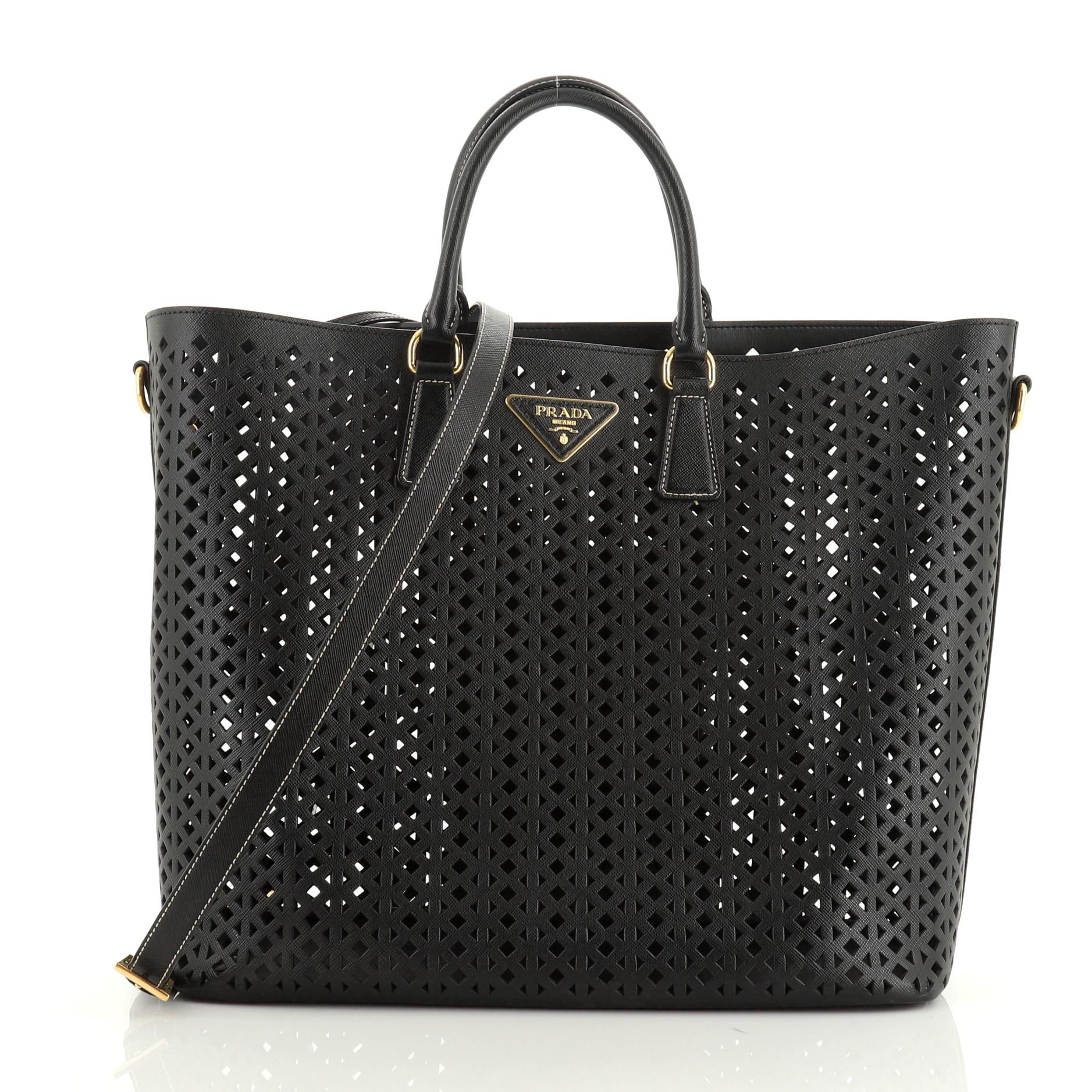 This Prada Convertible Open Tote Perforated Saffiano Leather Large, crafted in black perforated saffiano leather, features dual rolled leather handles, raised Prada logo at the center and gold-tone hardware. It opens to a black perforated leather