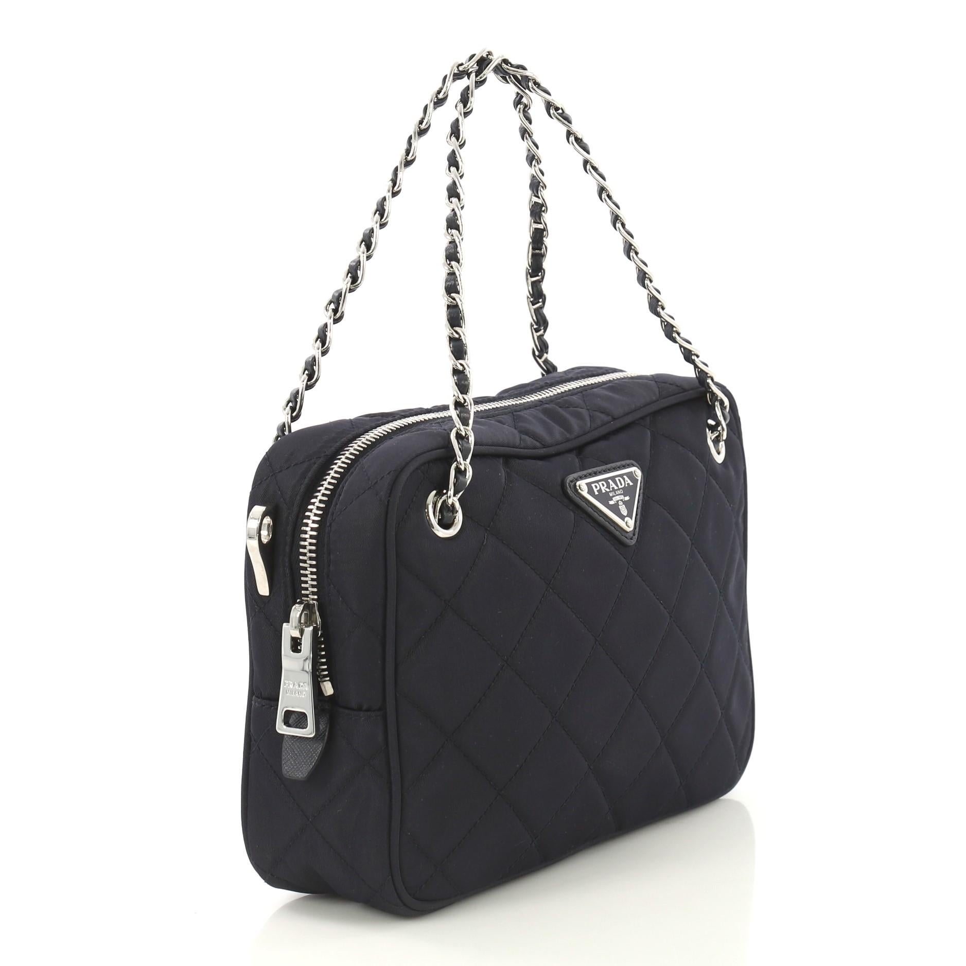 This Prada Convertible Shoulder Bag Quilted Tessuto Medium, crafted in navy quilted tessuto, features woven-in leather chain straps and silver-tone hardware. Its zip closure opens to a navy fabric interior with zip and slip pockets. 

Condition: