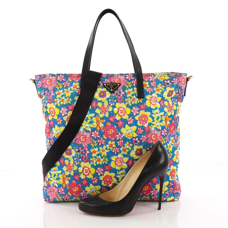 This Prada Convertible Tote Printed Tessuto With Saffiano Large, crafted from printed tessuto with saffiano, features a floral print design, dual-top leather handles, Prada logo, and gold-tone hardware. Its top zip closure opens to a black fabric