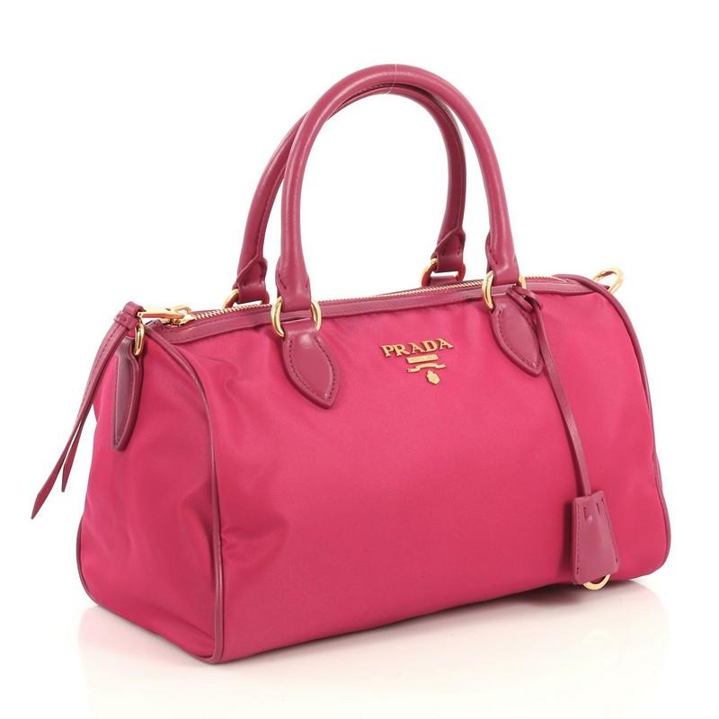 This Prada Convertible Tote Tessuto Medium, crafted from pink tessuto nylon, features dual rolled handles, gold-tone Prada logo, and gold-tone hardware. Its zip closure opens to a pink fabric interior with side zip and slip pockets. 

Estimated