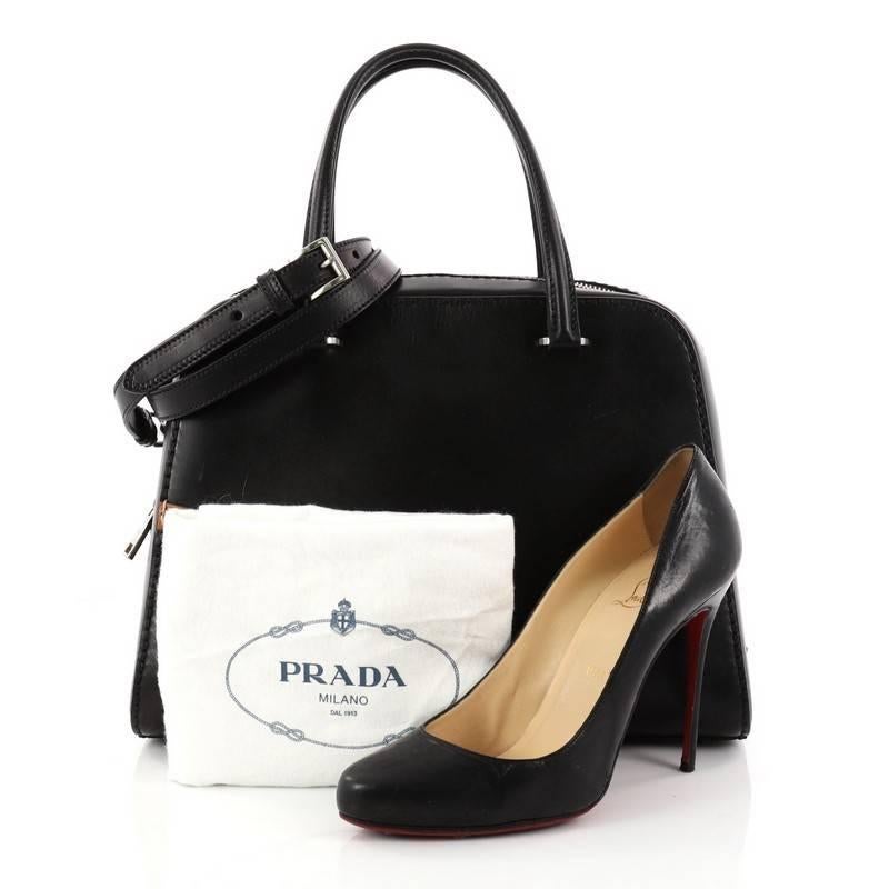 This authentic Prada Convertible Zip Around Satchel Vachetta Leather Medium is ideal for everyday use. Crafted in black leather, this satchel features dual top leather handles, vachetta leather trims, protective base tabs and matte silver-tone