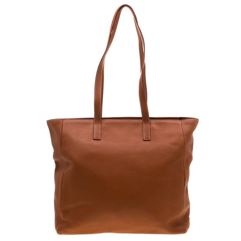 This shopper tote from Prada is a timeless piece and a worthy closet investment. The bag comes in a luxurious orange leather exterior with gold-tone hardware. It features dual top handle straps and a zip pocket to the front with topstitch details.