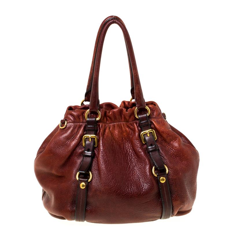 Look classy and sophisticated in this Prada hobo. Get yourself this stylish leather bag for a modern look. It is lined with nylon to store your essentials which adds to its functionality. The bag flaunts dual handles, a single shoulder strap and the