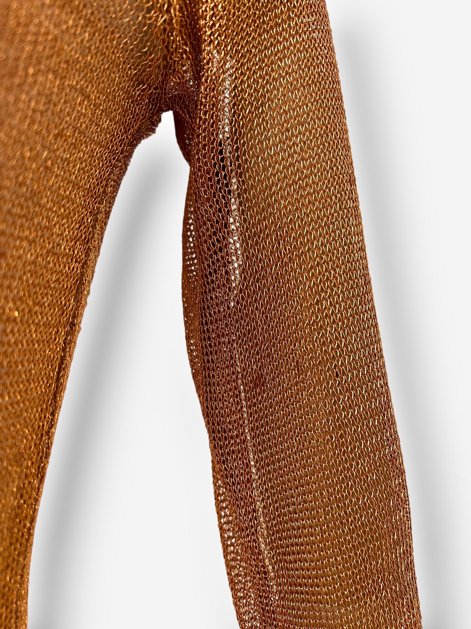 Pièce d'archive rare des collections de Prada du début des années 1990, cette robe en maille métallique dorée à l'or rose témoigne du glamour discret et de l'esprit d'innovation de la marque. Conçue avec une encolure légèrement échancrée et des