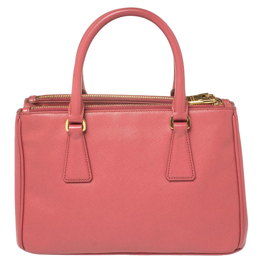 Feminine in shape and design, this Double-Zip Galleria tote by Prada will be a loved addition to your closet. It has been crafted using Saffiano Lux leather and styled minimally with gold-tone hardware. It comes with two top handles, nylon-lined