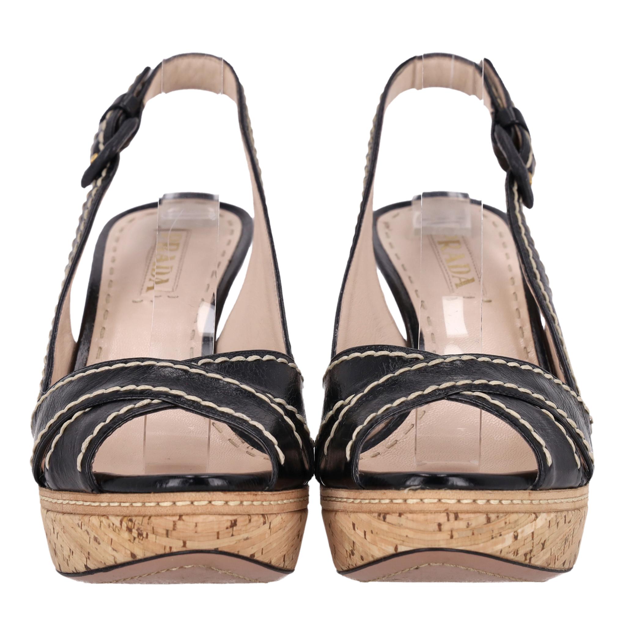 Prada Pumps in pelle con zeppa in sughero

Sandali neri realizzati in pelle con un design a cinturino incrociato con cuciture bianche contraenti.

Caratterizzate da cinturino regolabile e plateau e tacco in sughero beige.

Prezzo di listino circa