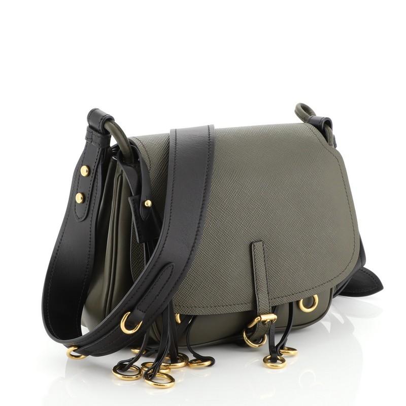 This Prada Corsaire Messenger Bag Calfskin and Saffiano Leather, crafted from green leather, features an adjustable shoulder strap, leather fringe with gold metal rings, front flap with buckle closure, magnetic flap pocket under flap and gold-tone