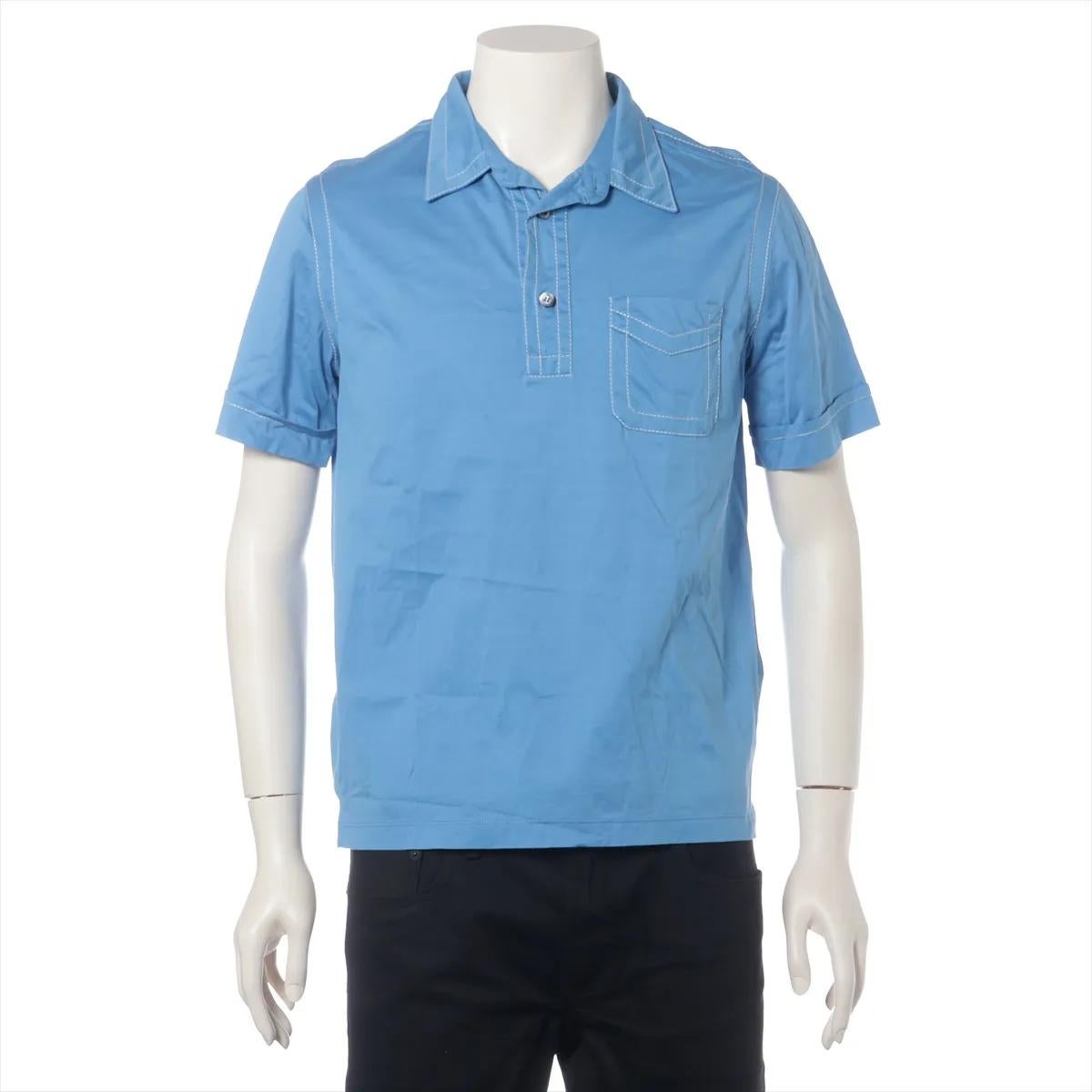 Le polo en coton Prada, de couleur bleue, est une pièce essentielle de la garde-robe, à la fois élégante et polyvalente, fabriquée en coton doux et perméable à l'air. Conçu avec une silhouette classique, il présente une patte de boutonnage à deux