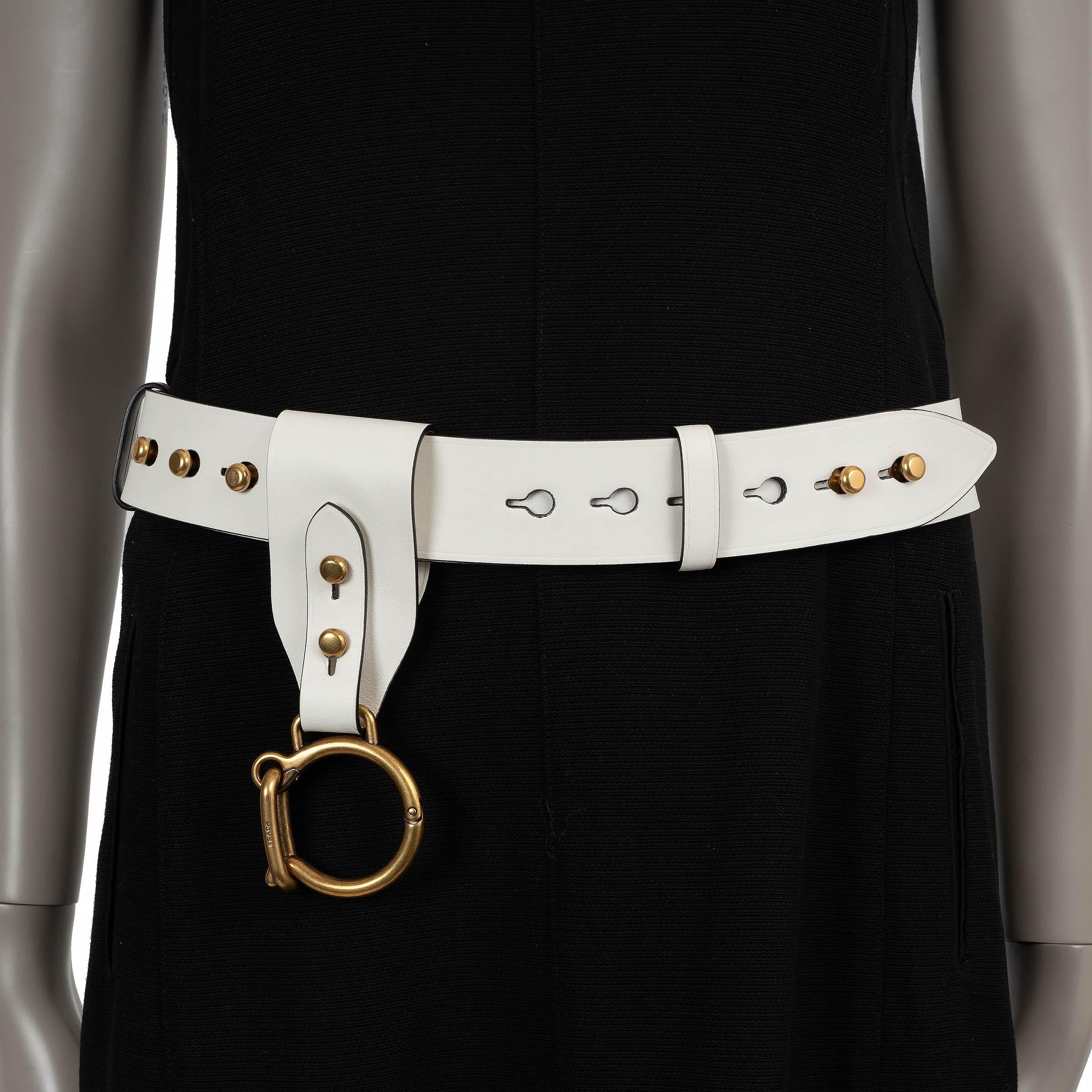 Este cinturón de pasarela Prada 100% auténtico está confeccionado en piel lisa de color crema e incluye un llavero de gran tamaño a juego en piel de color crema con detalles en dorado envejecido. Diseñada con un cierre de pasador y orificio y una