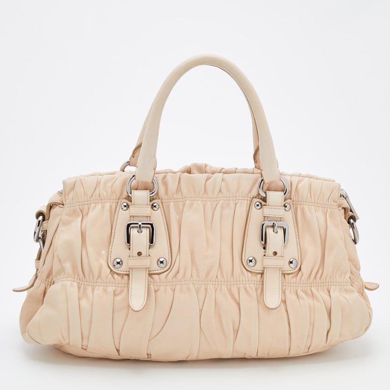 Carry your daily essentials in style in this Prada Gaufre satchel. It comes crafted in leather. The cream exterior features double top handles and silver-tone details. The top zipper opens to a roomy interior and features pockets.

Includes: Strap