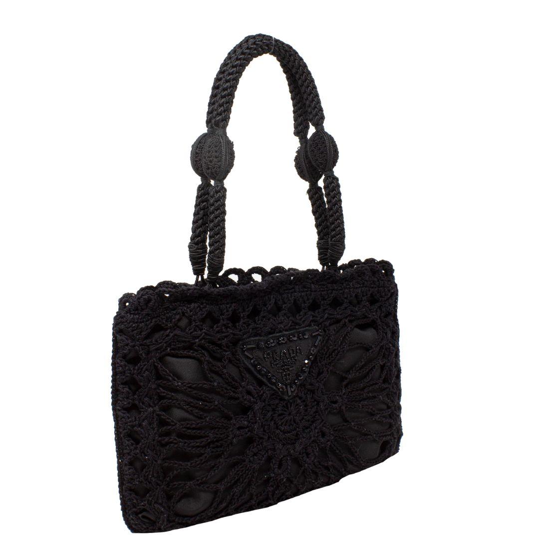 So adorable and rare! This Prada crochet top handle bag is such a vintage gem. With a beautiful beaded crochet logo plate, silver-tone hardware, dual braided handles, the magnetic snap closure opens up to a nylon lining with a single interior
