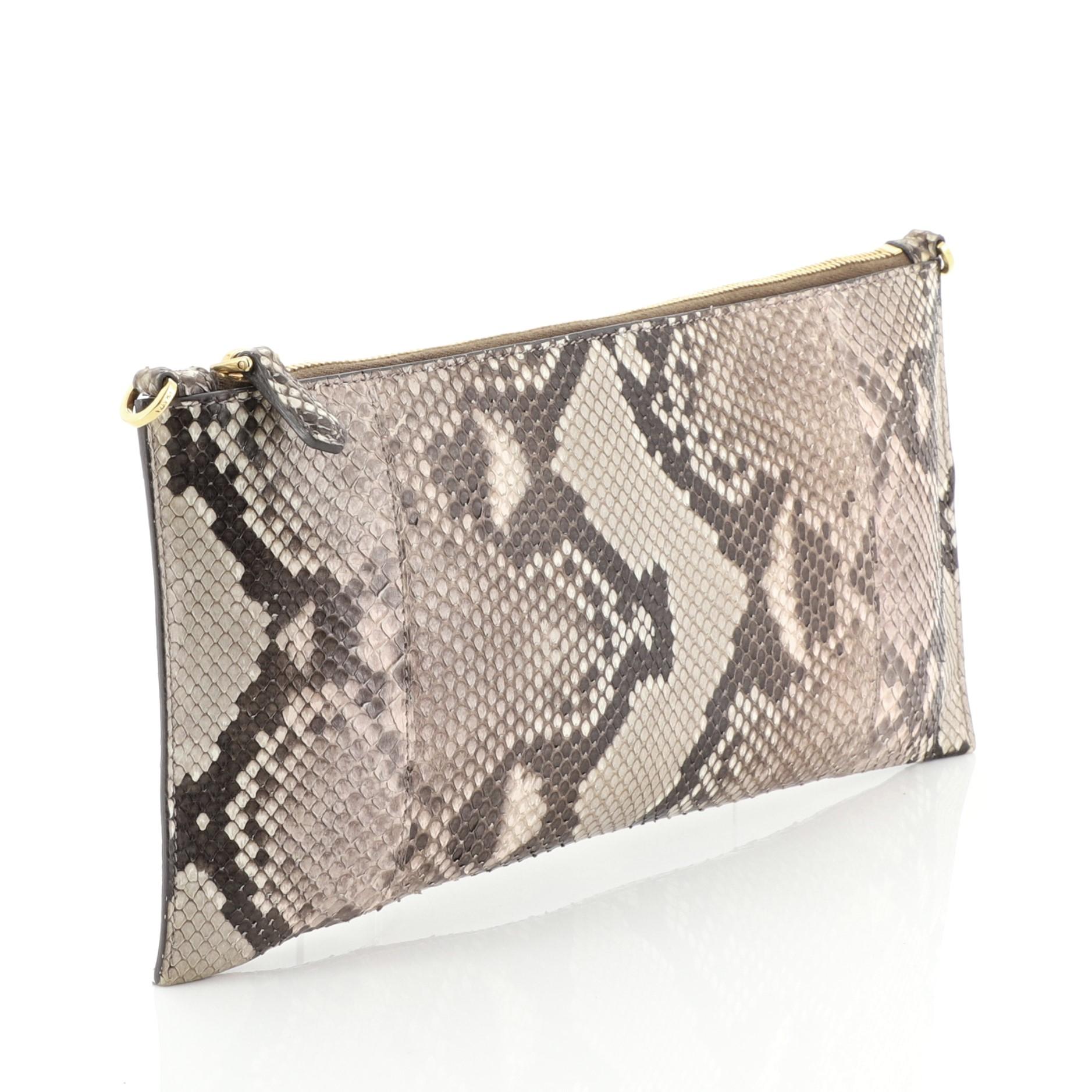 This Prada Crossbody Bag Python Small, crafted in genuine neutral python, features an adjustable strap and gold-tone hardware. Its zip closure opens to a brown leather interior with zip and slip pockets. This item can only be shipped within the