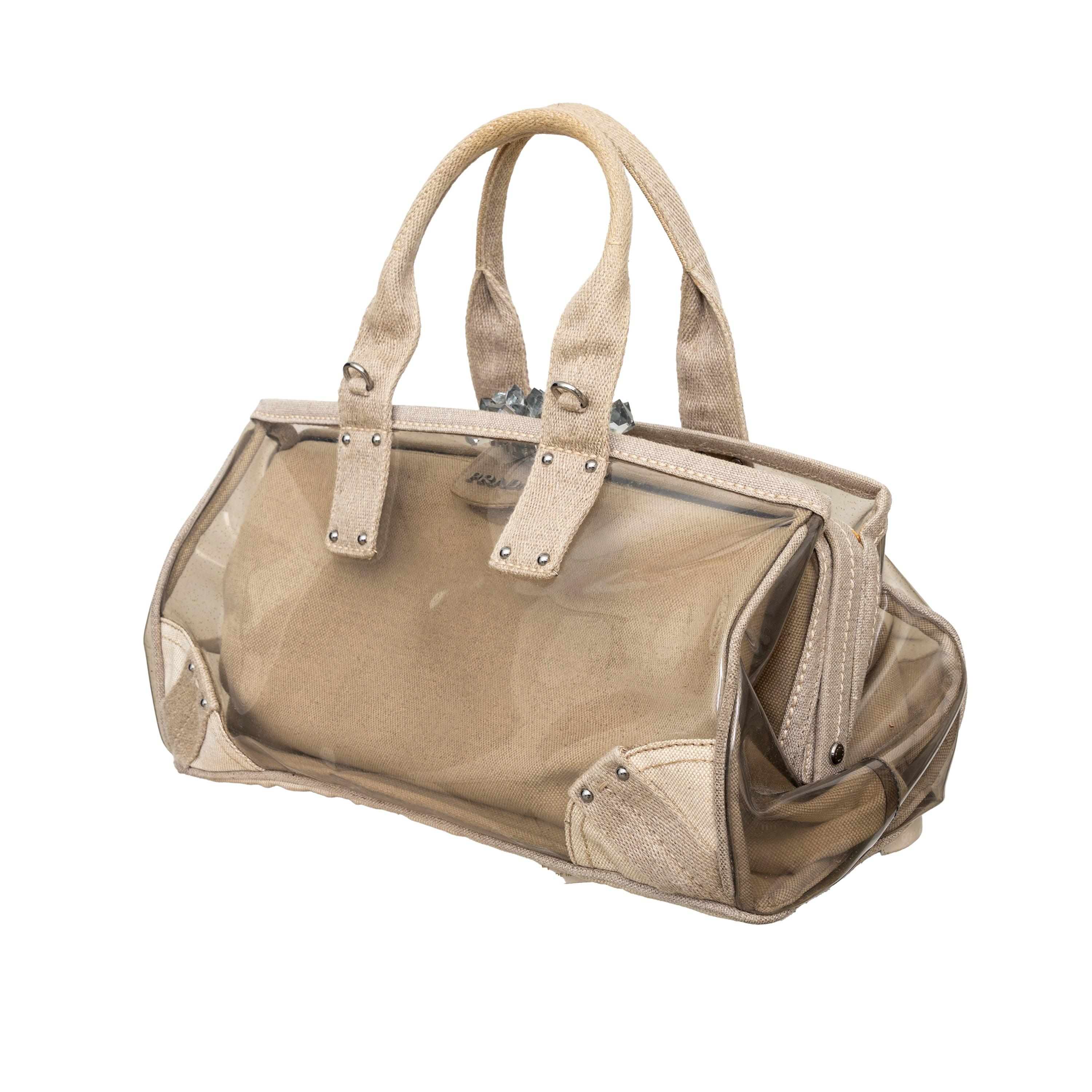 Add a touch of avant-garde elegance to your daily look with the Prada Crystal Embellished PVC Canvas Frame Bag. The frame top is adorned with resin-crystals that sway and shimmer with movement. The glossy PVC exterior is perfect for storing your