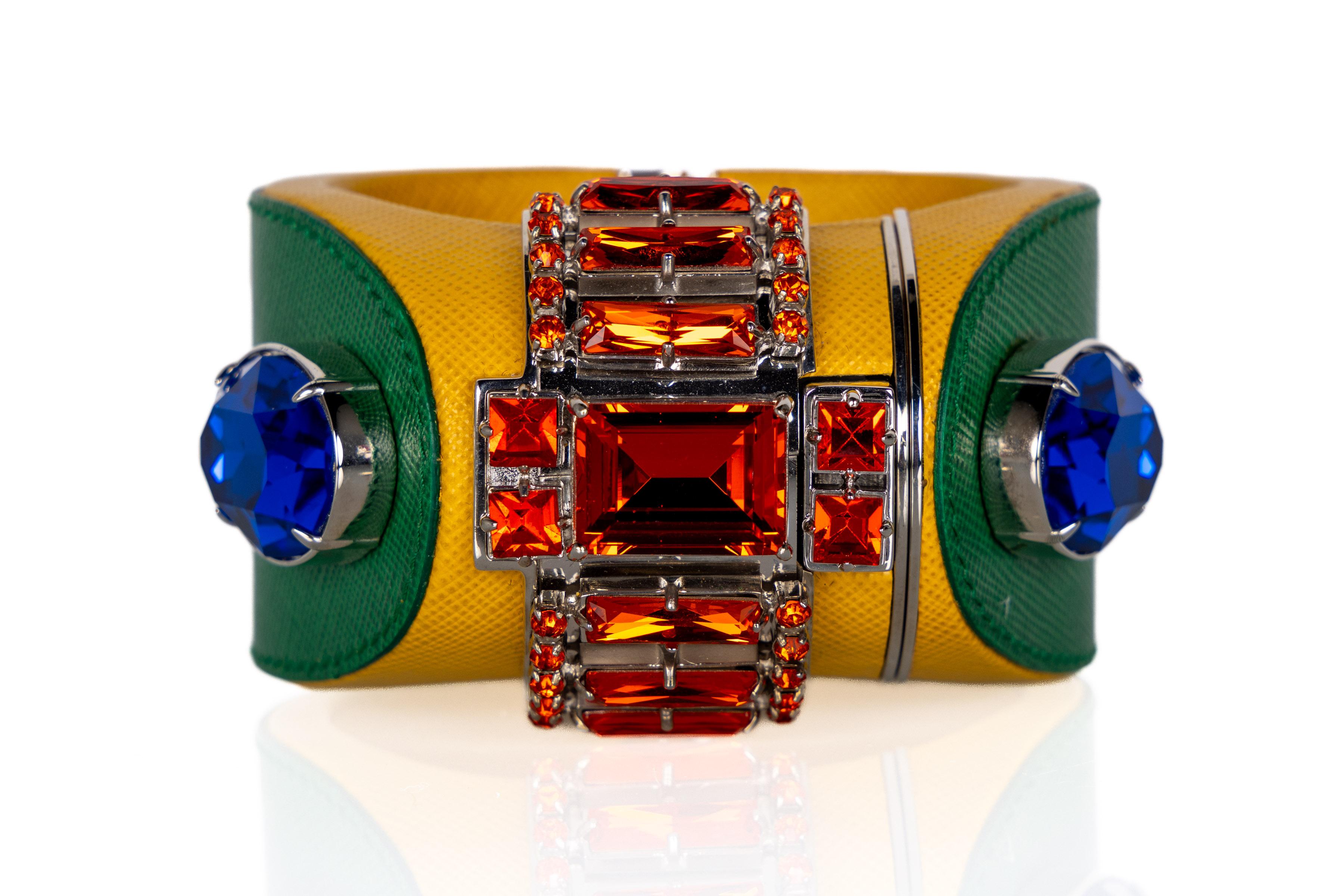 Introducing the vibrant and captivating Prada Saffiano Leather Cuff Bracelet from the Spring 2014 collection, featuring an array of striking colors.  This remarkable accessory combines the luxurious allure of yellow and green Saffiano leather with
