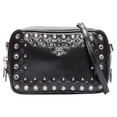 Bolso cámara crossbody de piel saffiano negra con logo de tachuelas de cristal plateado de PRADA