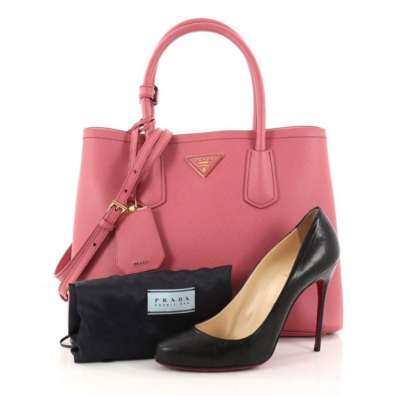 This authentic Prada Cuir Double Tote Saffiano Leather Small updates its popular Cuir line with a fresh, twist. Crafted from pink saffiano leather, this luxurious tote features dual-rolled top handles, side snap buttons, Prada's trademark triangle