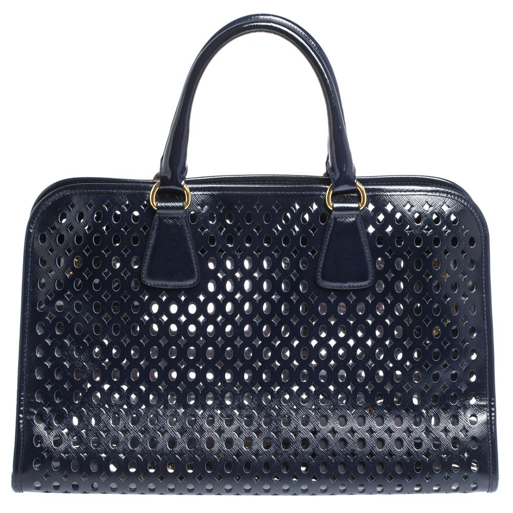 High on appeal and style, this tote is a Prada creation. It has been crafted from perforated patent leather and shaped to exude class and luxury. The bag comes with two handles, a spacious PVC & leather interior, and gold-tone hardware. Protective