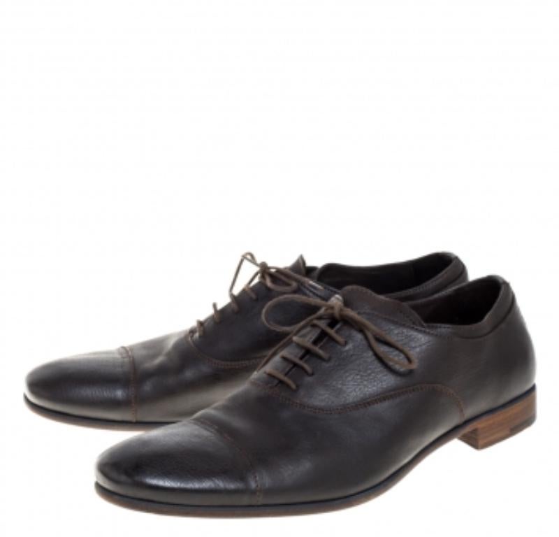 These classic and timeless oxfords by Prada fit perfectly into your formal closet. Crafted from dark brown leather, these shoes feature neat stitching and lace-up fronts. They are finished with well-lined insoles and low heels.