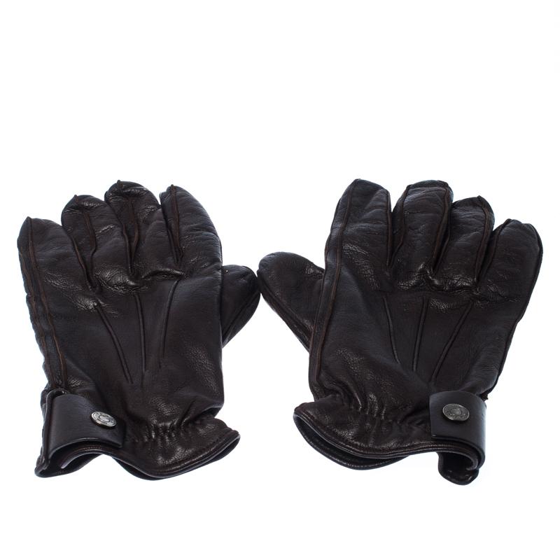 Gear up for the winters with this pair of Prada gloves. Made from leather, they are designed to keep your hands warm and comfortable. Coming in a simple design, they carry a dark brown hue and silver-tone button fastening.

Includes: The Luxury