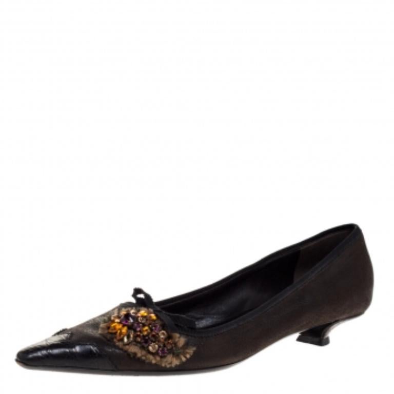 Pick this pair of Prada pumps to flaunt a simple yet stylish look. Beautifully designed, this pair of pumps feature a beautiful leather body. They come in a lovely shade of dark brown and are styled with pointed toes, crystal embellished uppers, and
