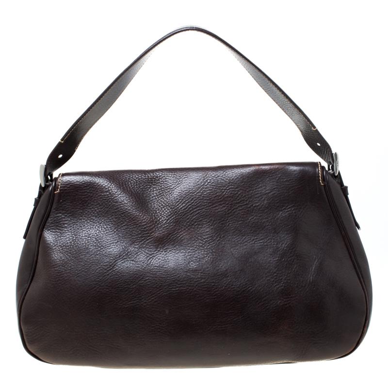 With a laid-back design, this fabulous Prada bag is crafted from dark brown leather. It flaunts a front flap that is secured by a buckle closure and opens to a well-sized interior. Carry the bag using the single handle.

Includes: Original Dustbag

