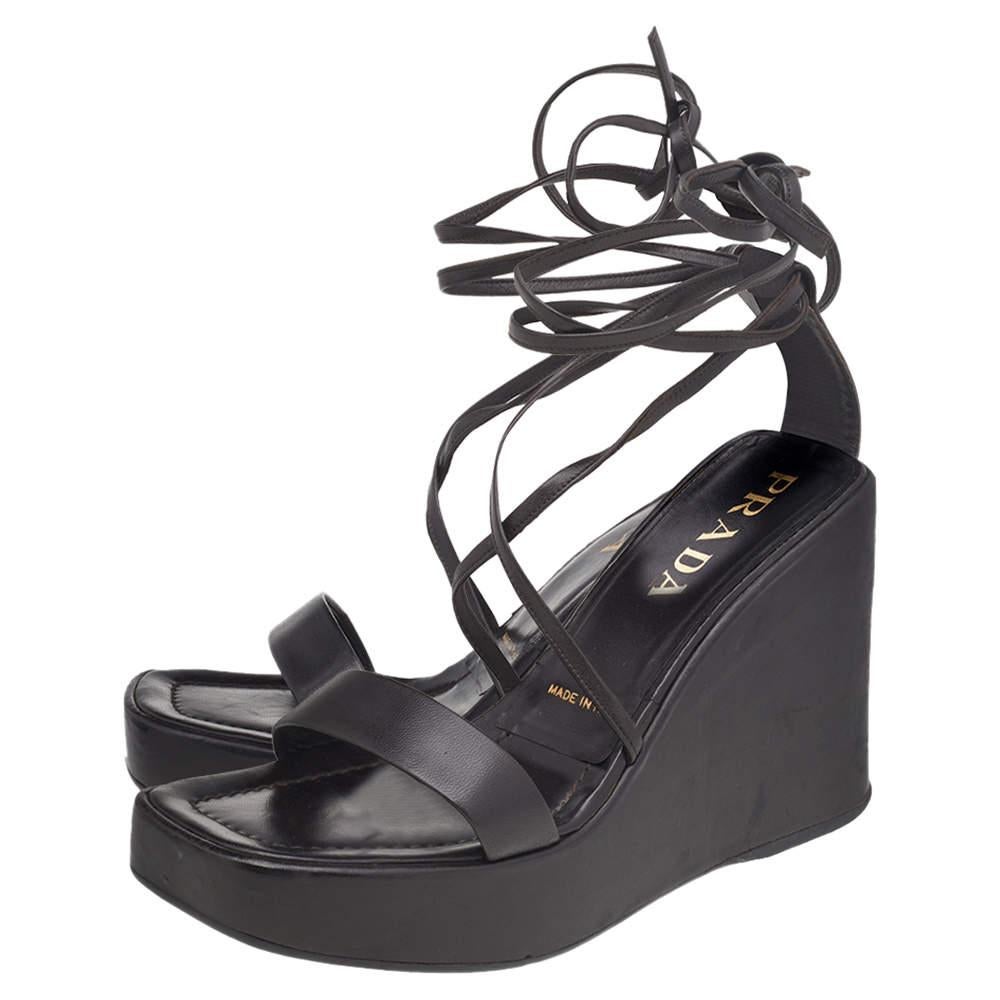 Feminines Flair, schlanke Schnitte und ein zeitloser Reiz zeichnen diese umwerfenden Prada Sandalen aus. Sie sind aus dunkelbraunem Leder gefertigt, haben eine offene Zehenpartie und einen hohen, von einem Plateau getragenen Absatz.

