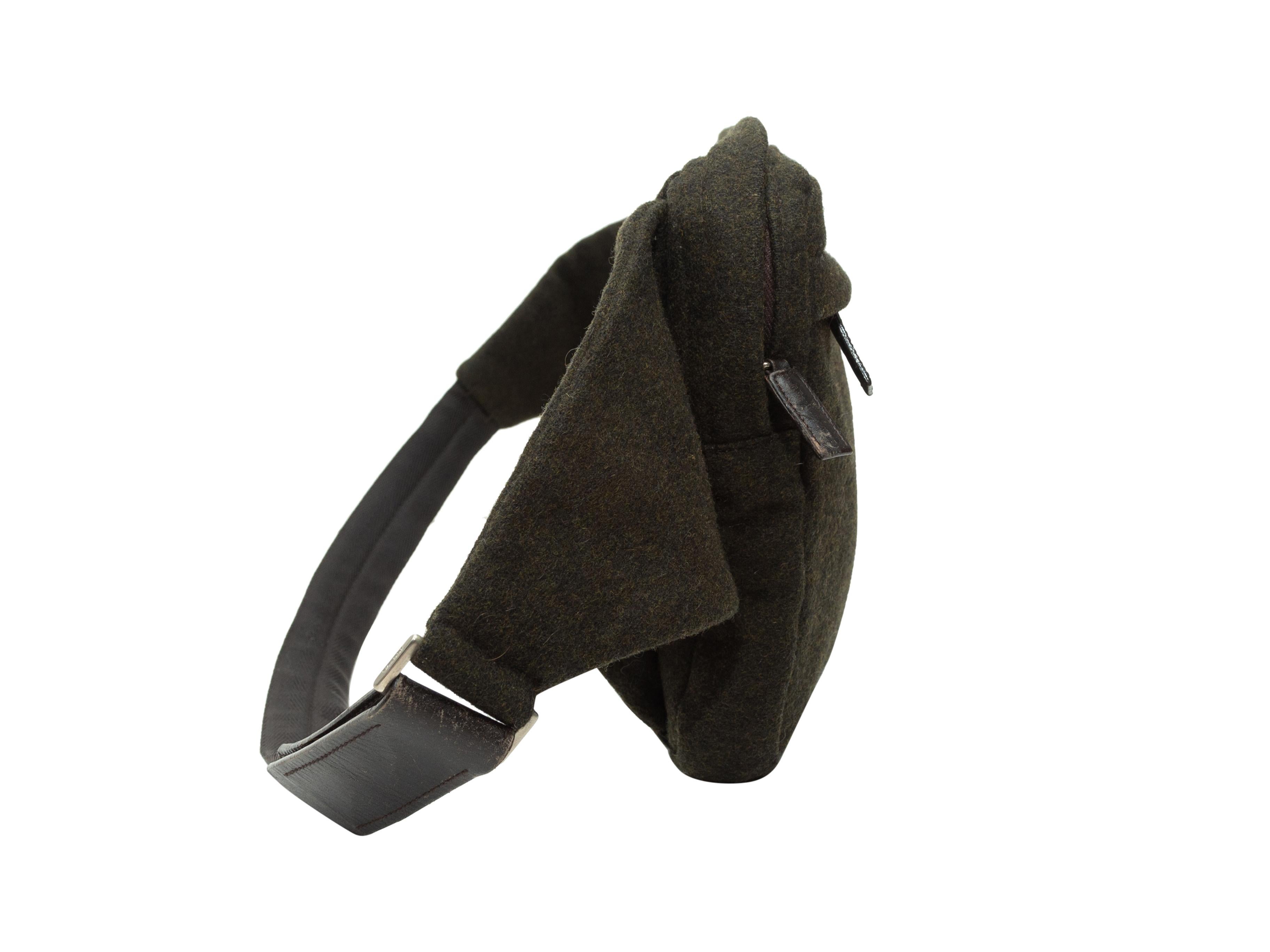 Product details: Dark brown wool belt bag by Prada. Front zip pocket. Leather trim. Adjustable waist strap. Zip closure at top. 11
