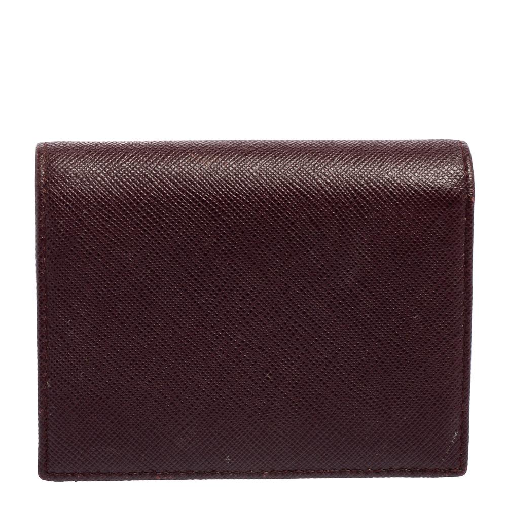 This Prada card case is crafted from a Saffiano Lux leather body. It features a bi-fold style that opens to reveal an interior equipped with slip compartments to neatly organize your cards.

