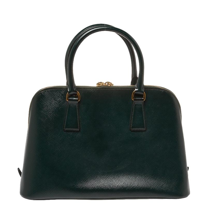 This stunning Promenade tote is high on appeal and style. Dazzling in a classy dark green shade, the bag is crafted from Saffiano patent leather and features two rolled handles. The zip closure leads way to a nylon interior with enough space for