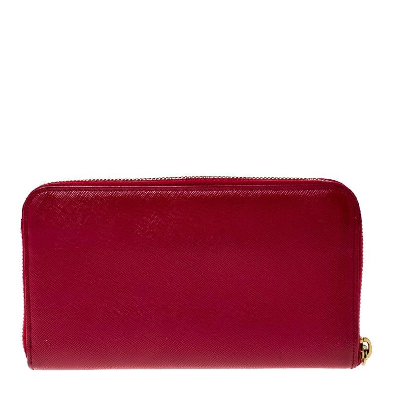 This wallet from Prada is one creation a fashionista like you must own. It has been wonderfully crafted from dark pink Saffiano lux leather. The gold-tone top zipper opens to reveal a leather-fabric lined interior featuring multiple card slots and a