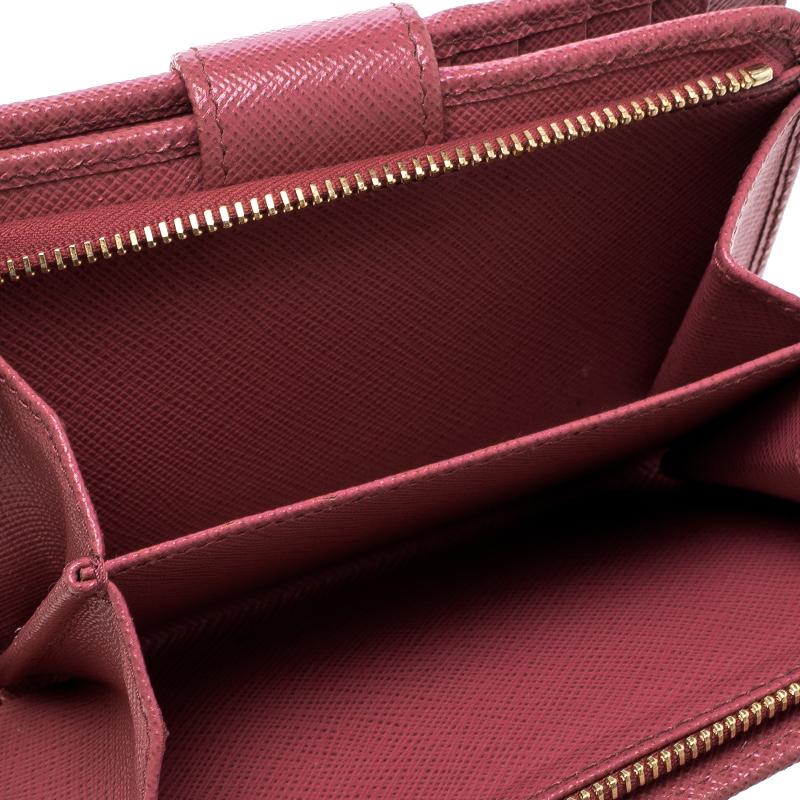 Designed for everyday use, this Zippy wallet by Prada is your super adorable and compact companion. Crafted from dark pink Saffiano leather, the wallet has a long billfold compartment, ten card slots, and one zipper coin pocket designed to hold all