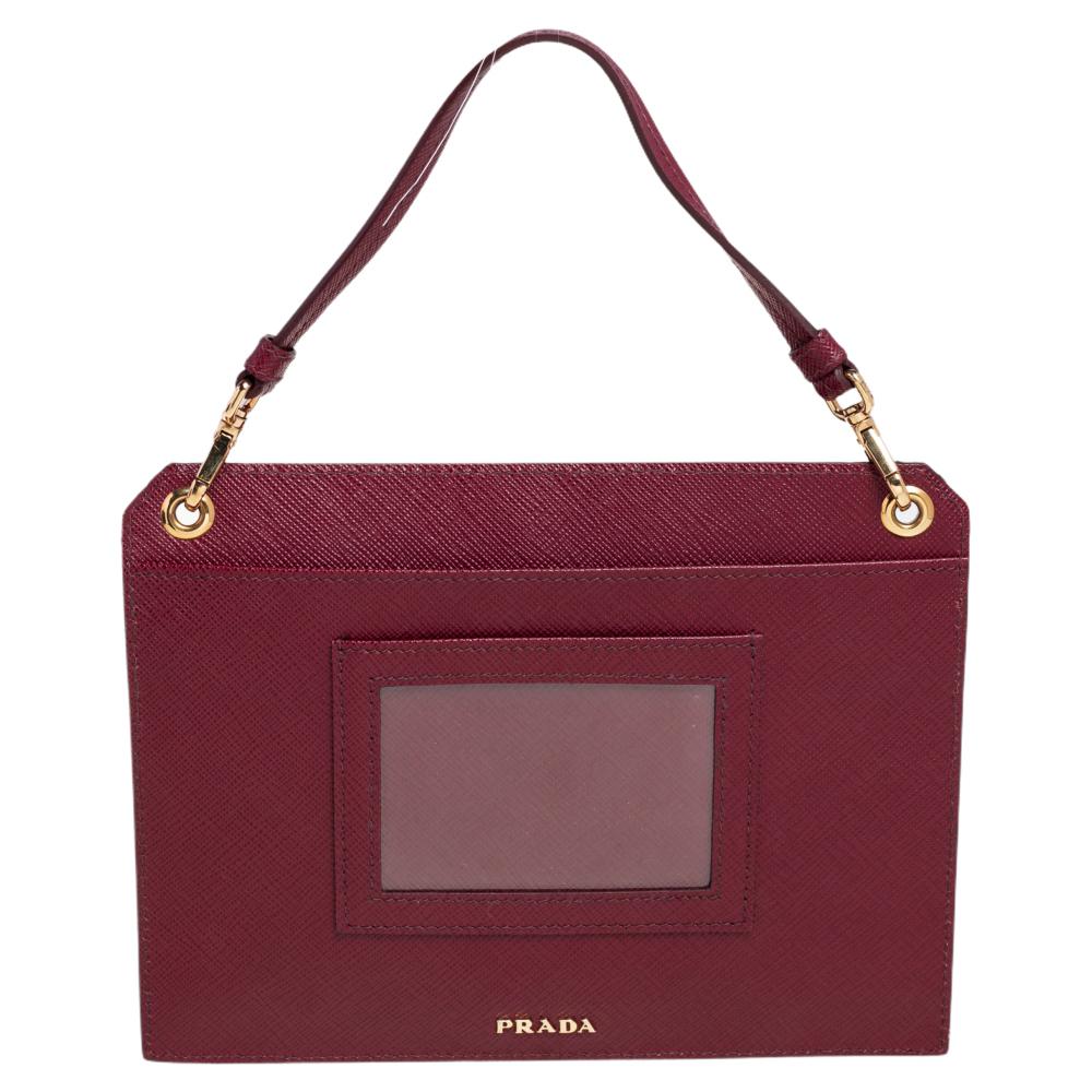 Renowned for its exclusive craftsmanship, this Prada crossbody bag will live up to your expectations. Crafted from Saffiano Lux leather, it comes in a dark red hue. It features a nylon interior equipped to house your essentials. It comes with a top