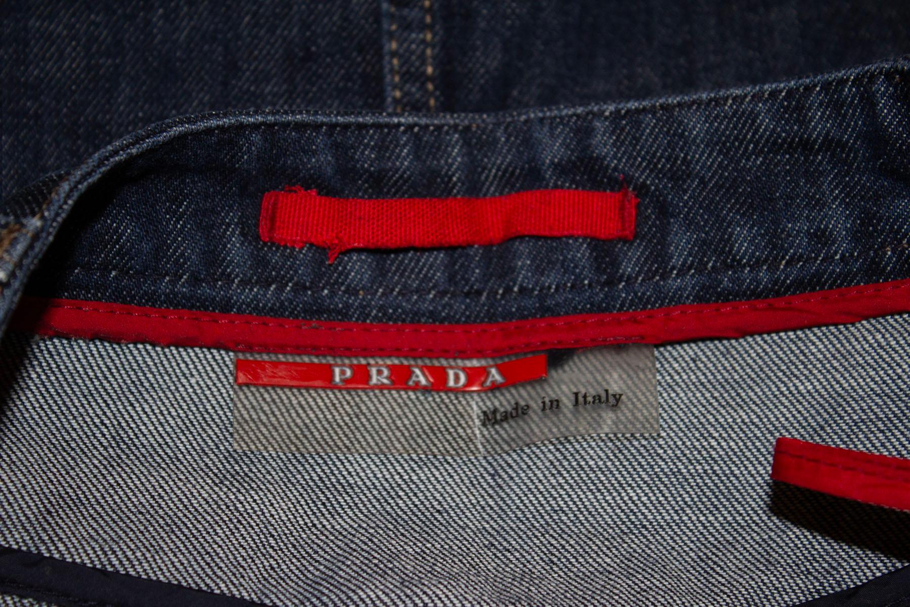 A chic denim skirt by Prada ideal for work and play. 
The skirt has a front central zip opening , and waist band with belt hoops. It has two pockets on the front , and a 15'' front slit. It is unlined. Italian size 40.
Measurements: Waist 29'',