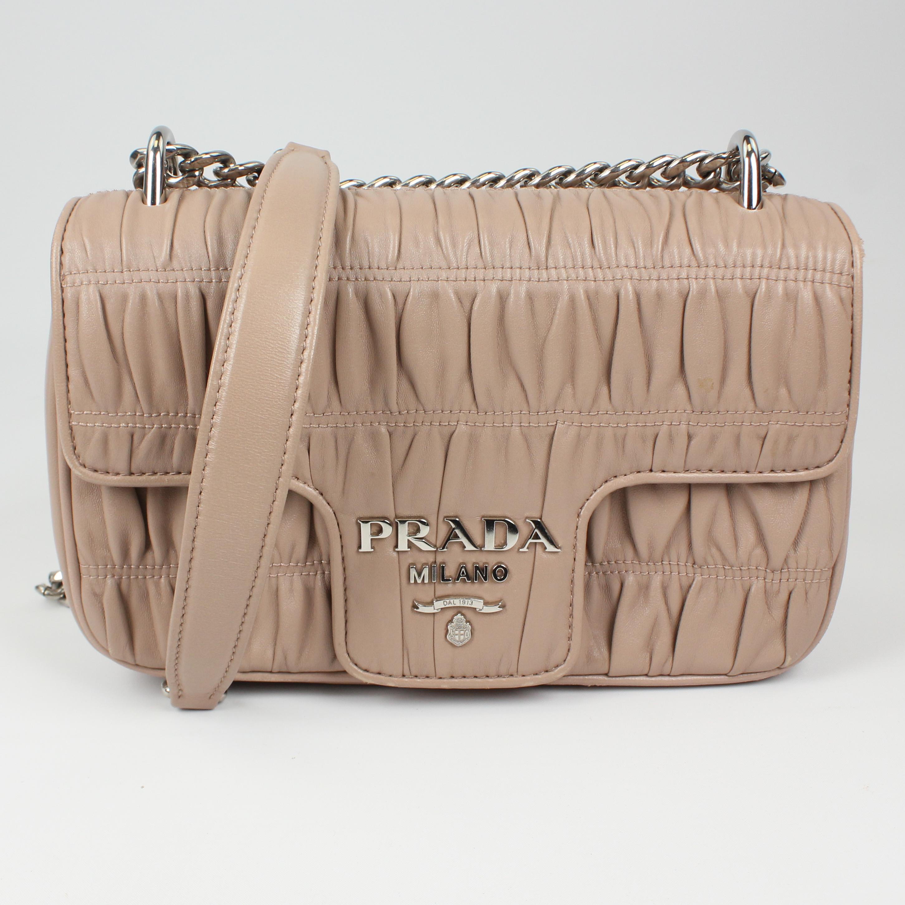 The flap has a nose-like design and the center is crafted with the new Prada logo. This handbag is the house’s latest design and it looks like it will pave its way to the iconic status. Also this handbag comes with a long chain strap for shoulder