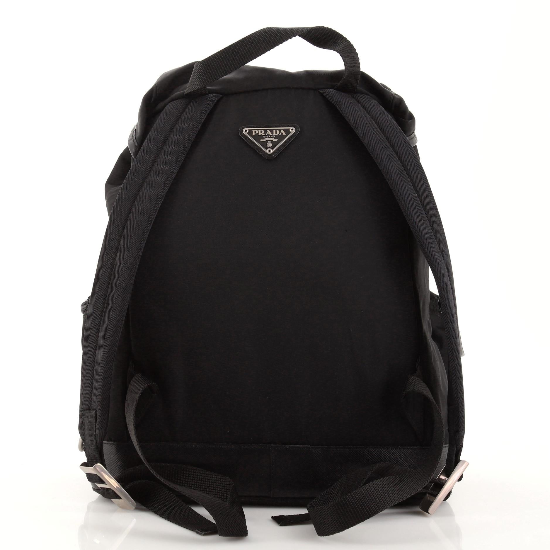 Prada Double Front Pocket Backpack Tessuto Medium. Moderate odor in interior. Heavy creasing, wear and scuffs on exterior and flap leather trims, small stain on rear and underneath flap, wear in interior, scratches on hardware.     76419MSC