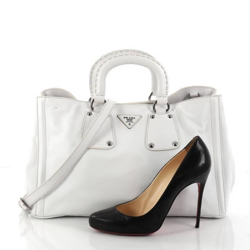 This authentic Prada Double Handle Convertible Shopping Tote Soft Calfskin Large is elegant in its simplicity and structure. Crafted from white soft calfskin leather, this tote features short dual-top leather handles, sides with snap closures,