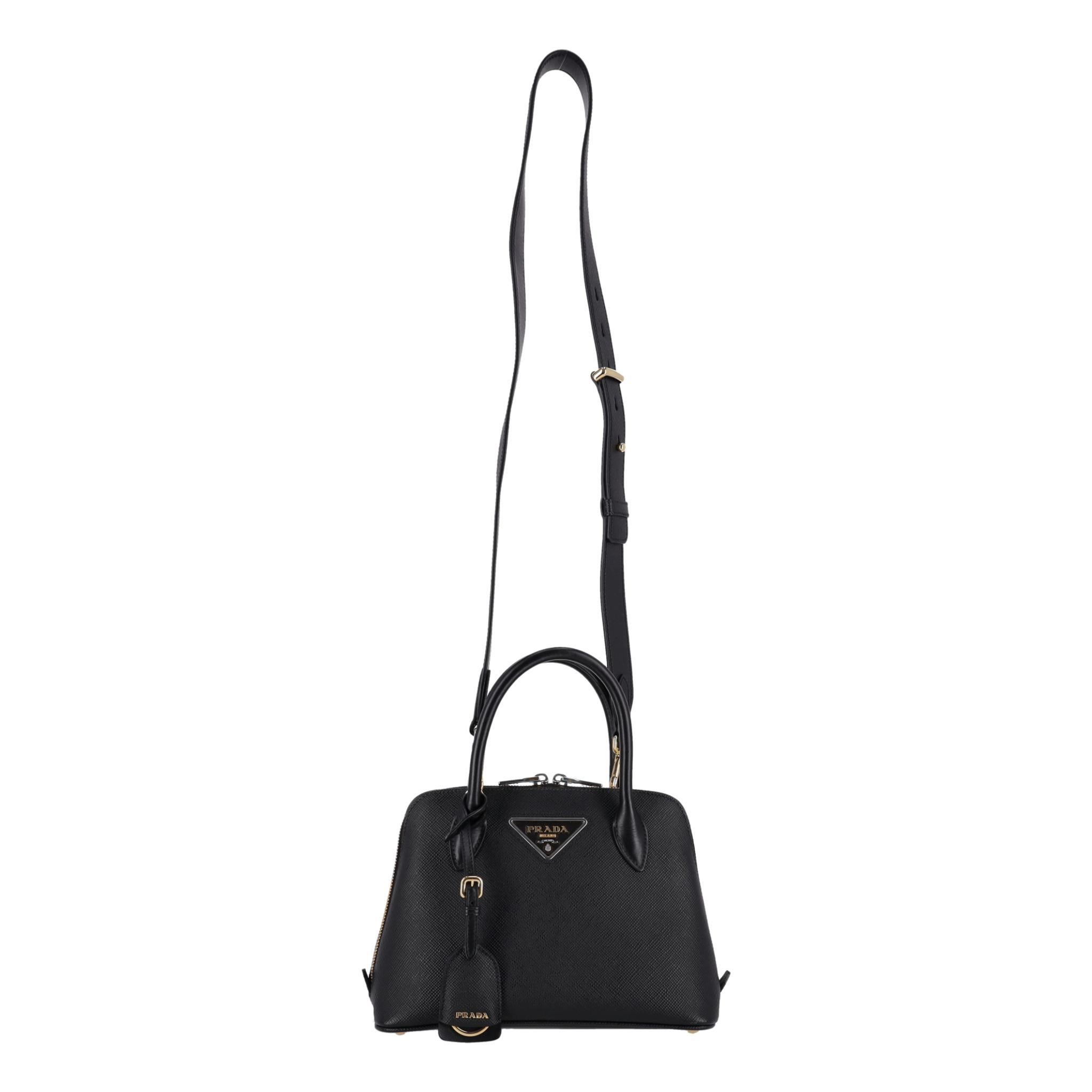 Prada Doppelte Saffiano-Ledertasche

Neues Mini-Design: Ein farblich abgestimmtes Lederdreieck umrahmt das ikonische Metall-Logo auf der Vorderseite, während der abnehmbare Schulterriemen es ermöglicht, die Tasche über der Schulter oder als