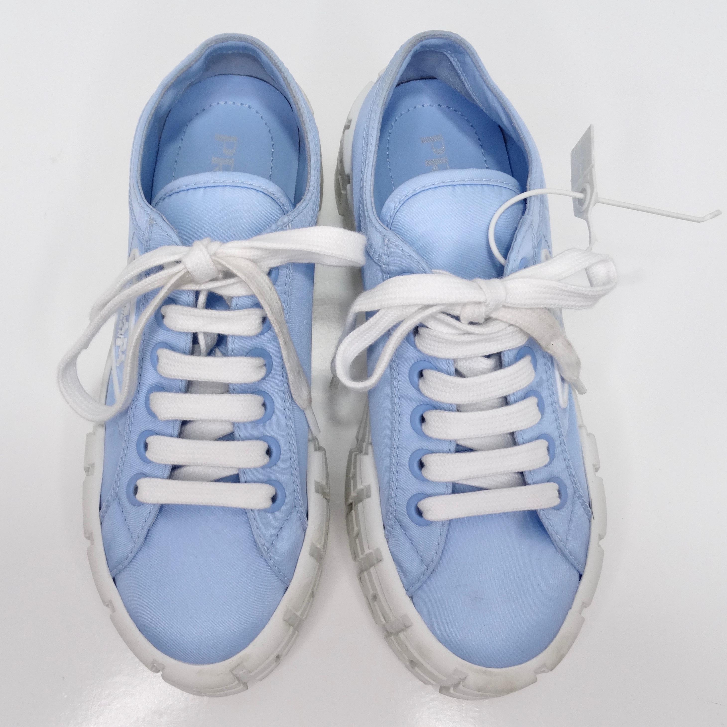 The Prada Double Wheel Re-Nylon Gabardine Sneakers in Light Blue are a stylish and statement-making addition to any footwear collection. These platform sneakers feature a chunky textured sole that not only adds height but also provides comfort and