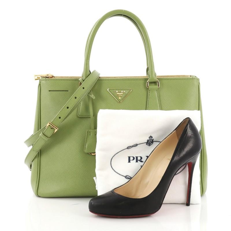 This Prada Double Zip Lux Tote Saffiano Leather Medium, crafted from green saffiano leather, features dual rolled handles, raised Prada logo plate, and gold-tone hardware. It opens to a green fabric interior with two zip compartments on both sides