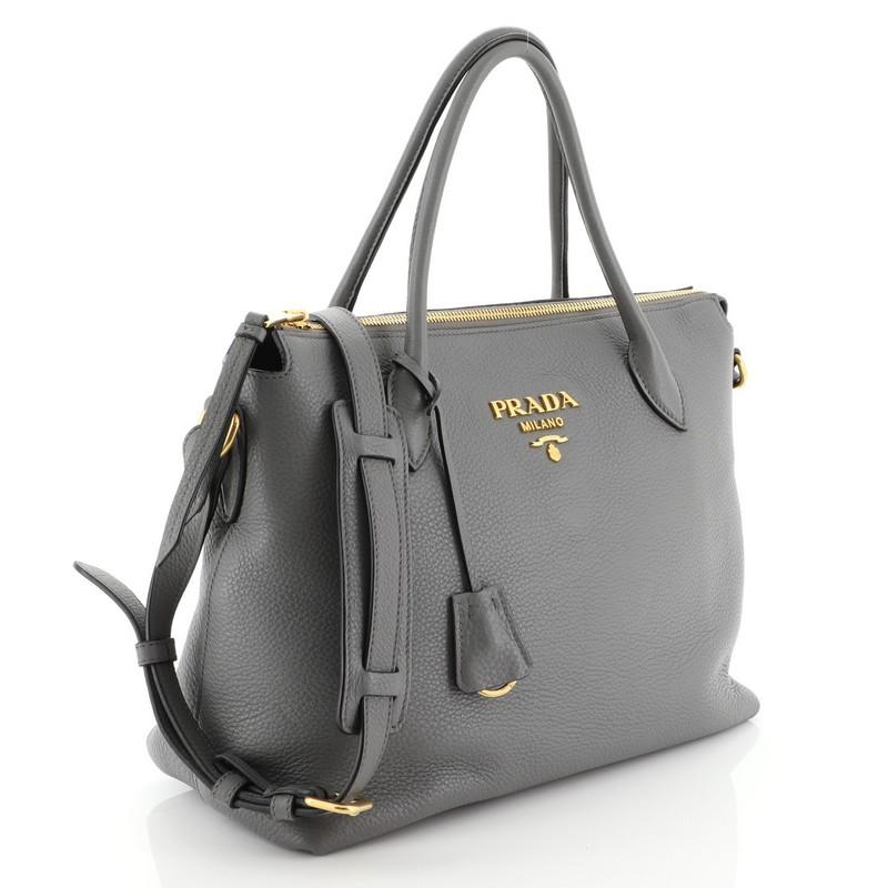 This Prada Dual Strap Zip Tote Vitello Daino Medium, crafted in gray Vitello Daino, features dual rolled leather handles, Prada logo and gold-tone hardware. Its zip closure opens to a black fabric interior with zip and slip pockets. 

Estimated