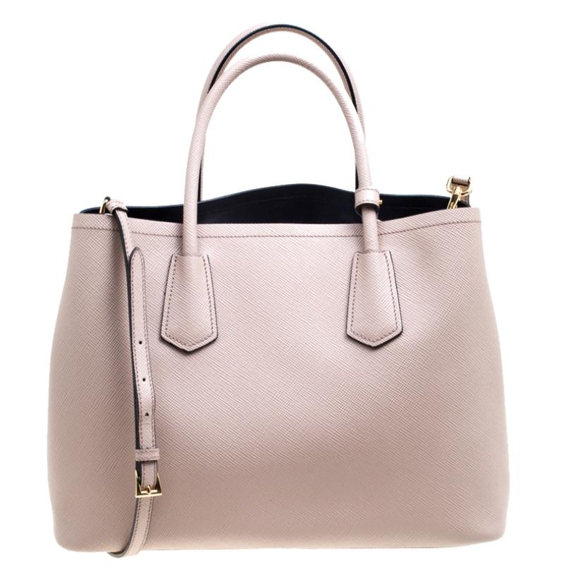 This elegant bag from Prada is reliable and packed with style. Crafted from leather it is perfect for daily use. The bag features double handles, a leather tag, and a removable shoulder strap. The leather lined interior is spacious enough to fit