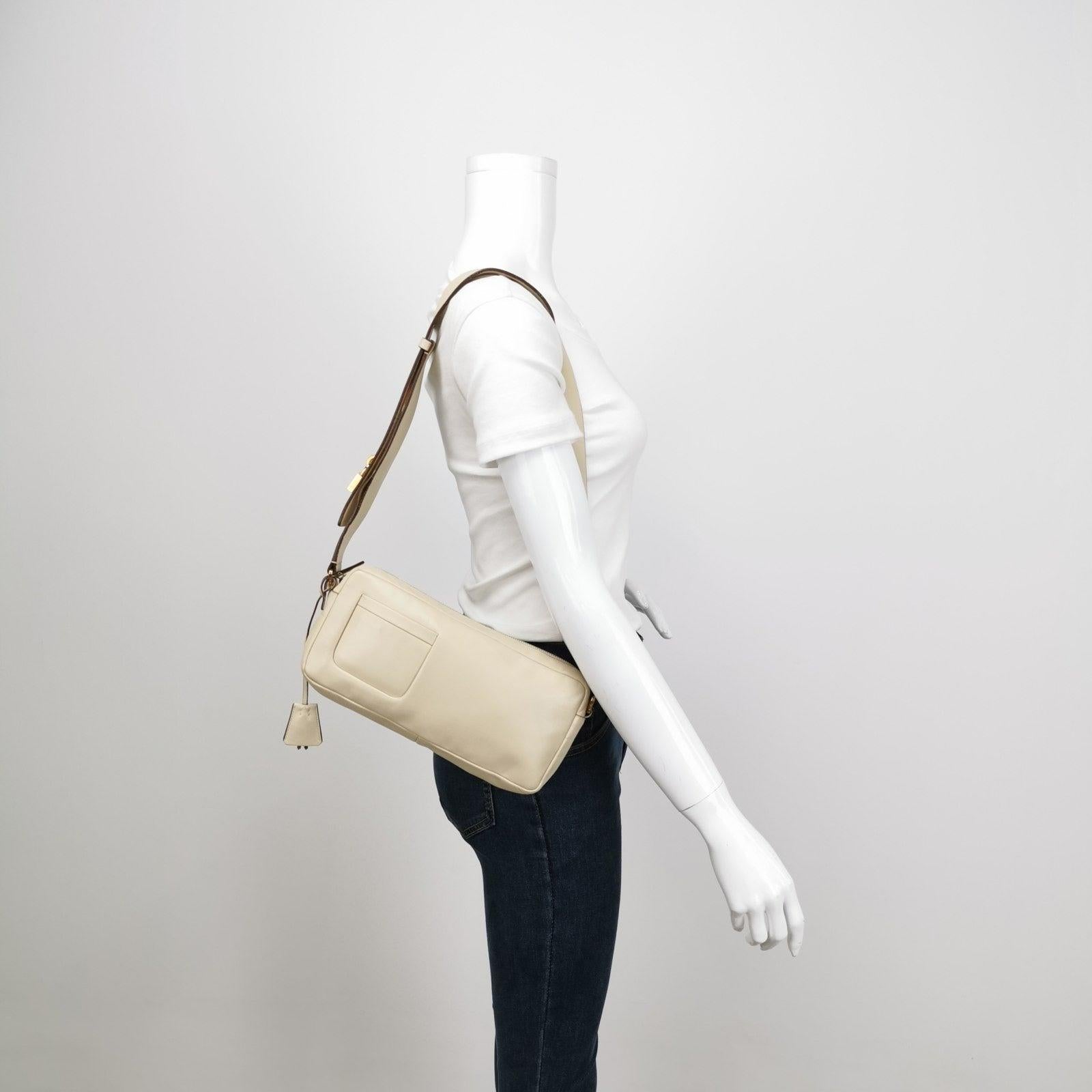 Prada East West Camera Bag Cream White Lambskin Leather with Gold-tone Hardware These are professional photos of the actual bag offered by Luxbags. This Prada shoulder bag is a rare find, crafted from cream white lambskin leather. Its elongated east