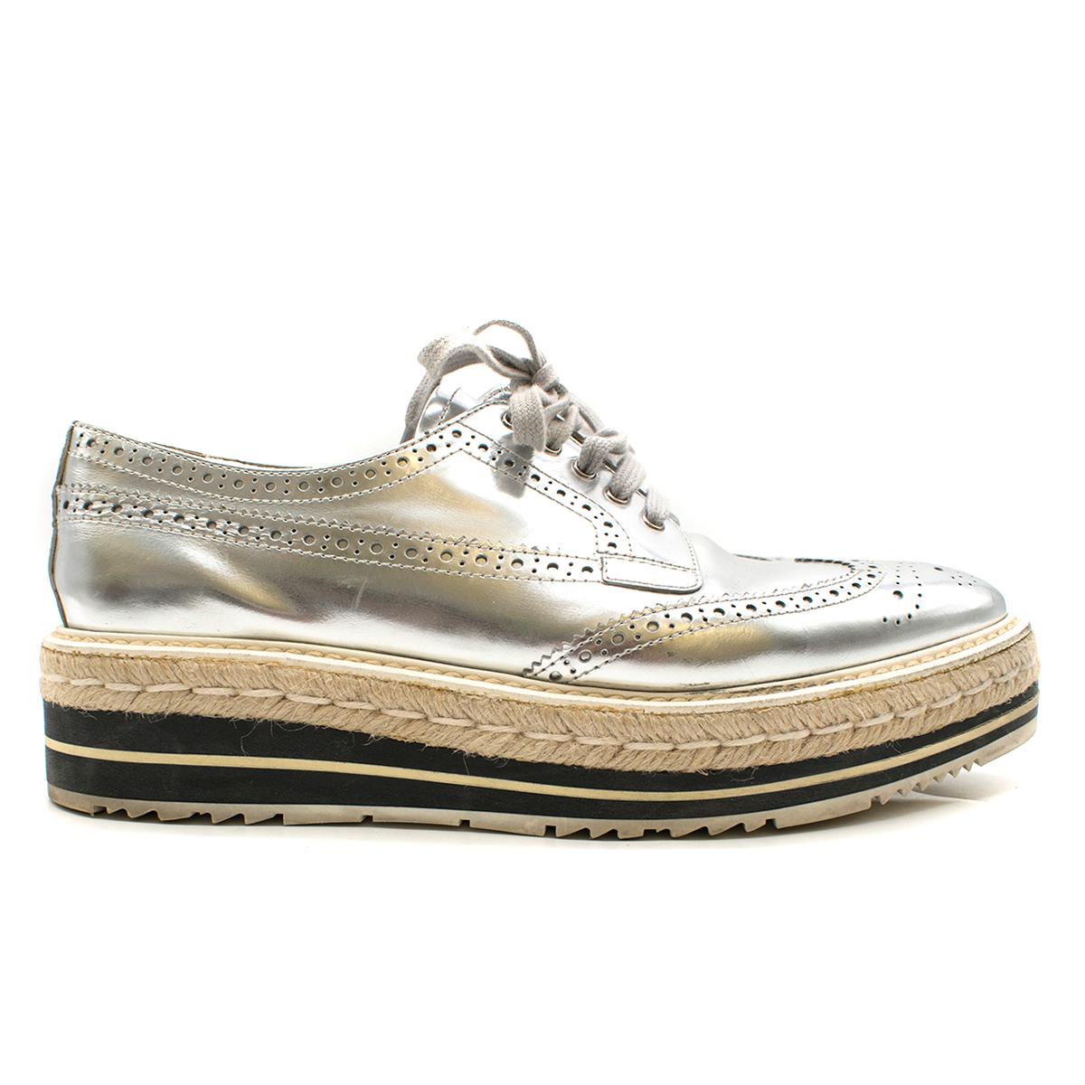 Prada Espadrille & Rubber-Platform Metallic Brogues

- Metallic Silver Broques
- Perforated Leather 
- Grey shoelaces
- Espadrille and rubber platform sole 
- Soft pointed toe 

Please note, these items are pre-owned and may show some signs of