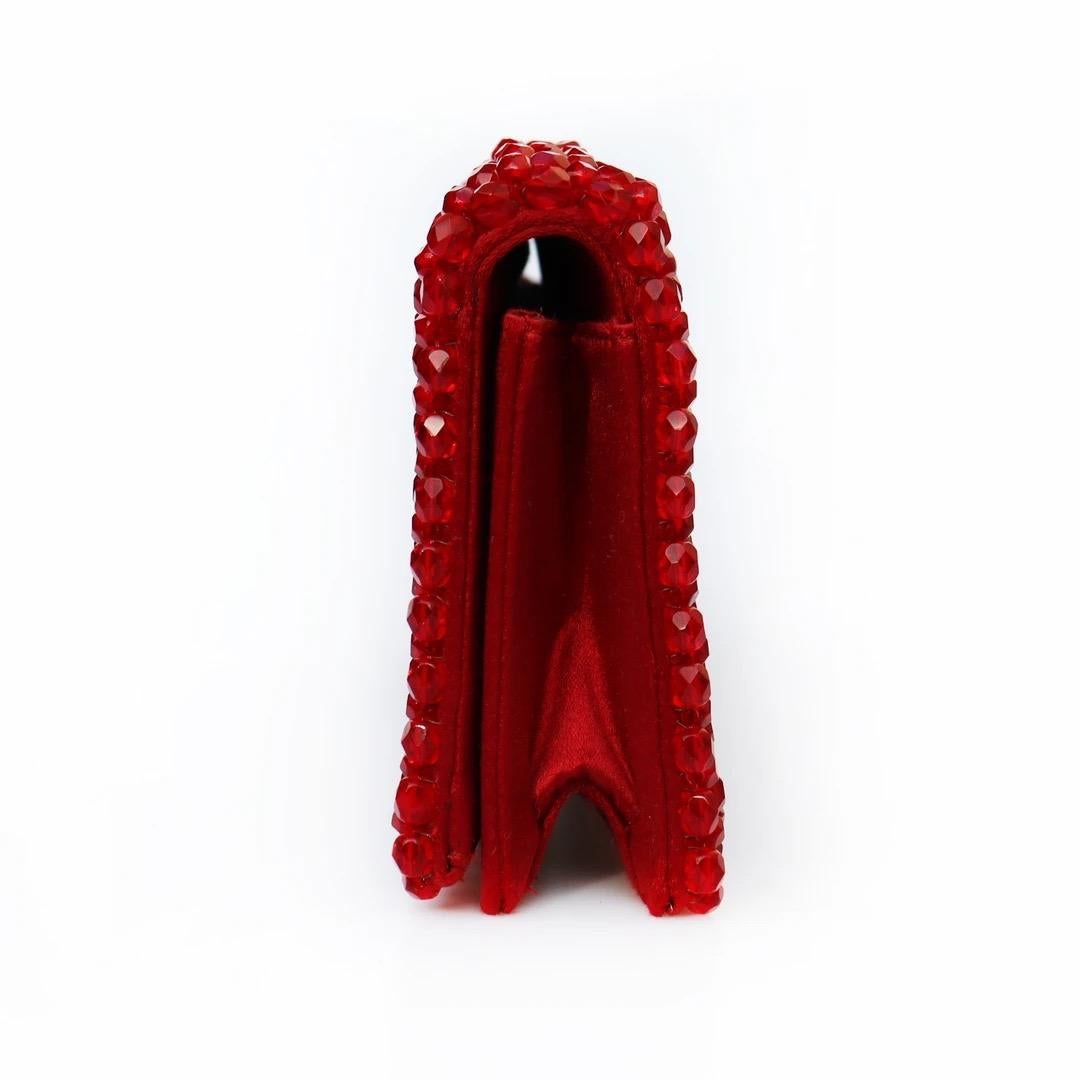 Prada Evening Clutch 
Made in Italy 
Red
Covered in sparkling faceted red beads in a geometric pattern 
Interior of handbag is red satin 
Handbag has snap closure 
Interior of handbag has open card pocket 
Red Enamel Prada tag inside of clutch 
Good